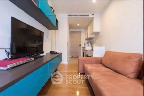 Modern living room with sleek blue cabinetry and cozy brown sofa