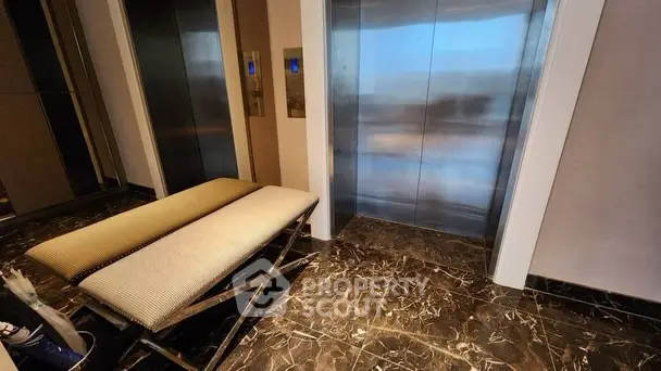 Luxurious building lobby with elegant elevators and stylish seating area.