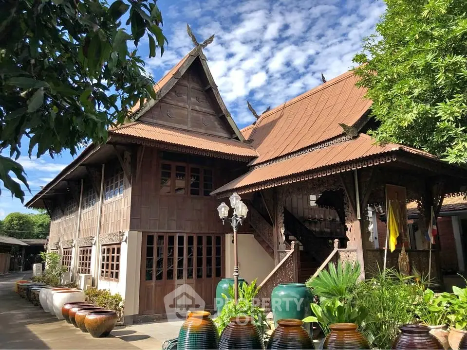 Charming traditional wooden house with intricate carvings and lush garden, perfect for cultural enthusiasts.