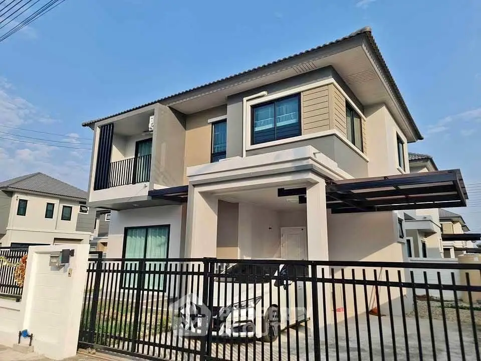 Modern two-story house with sleek design and gated driveway in suburban neighborhood.
