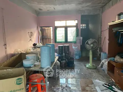 Spacious room with potential for renovation, featuring large window and ample storage space.