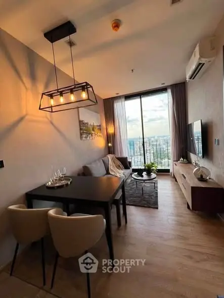 Modern living room with stylish decor and large window offering stunning city view.
