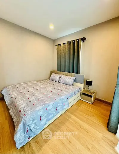 Cozy bedroom with modern decor and wooden flooring, featuring a comfortable bed and stylish curtains.