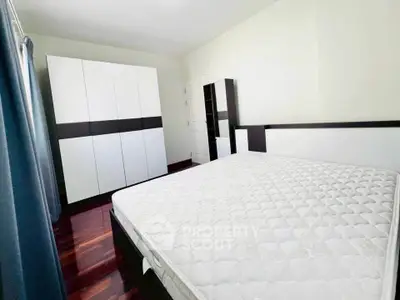 Spacious bedroom with modern wardrobe and large bed, perfect for comfort and style.