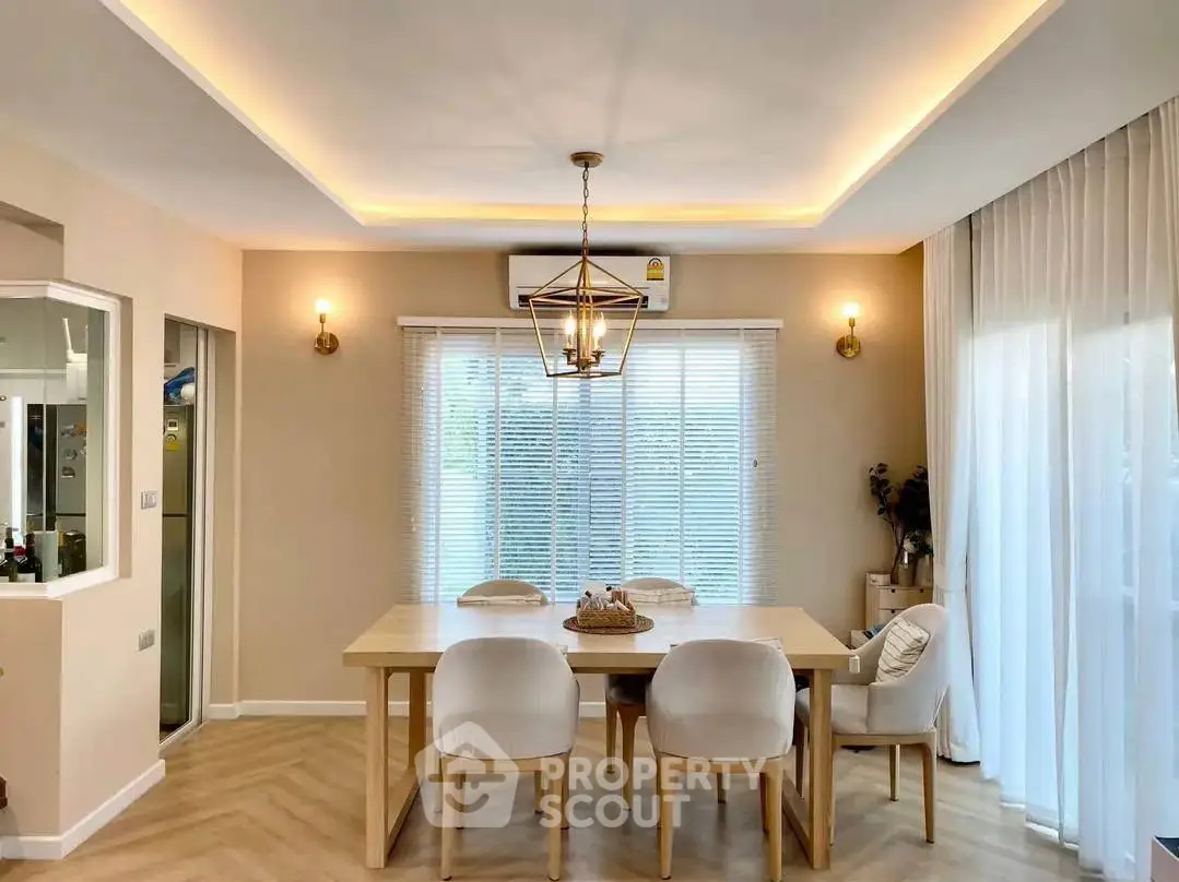 Elegant dining area with modern lighting and natural light from large windows.