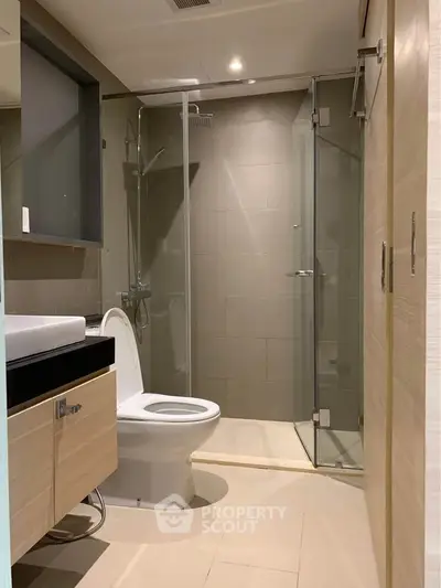Modern bathroom with glass shower and sleek fixtures in a contemporary apartment.