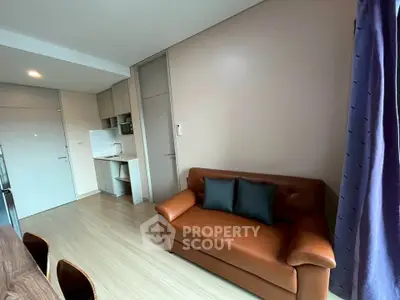 Modern living room with leather sofa and open kitchen layout