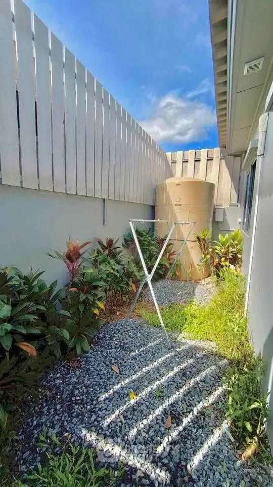 Charming outdoor garden space with gravel path and lush greenery, perfect for relaxation.