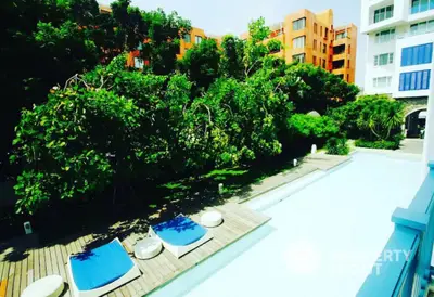 Luxurious poolside view with lush greenery and modern architecture in a serene residential complex.