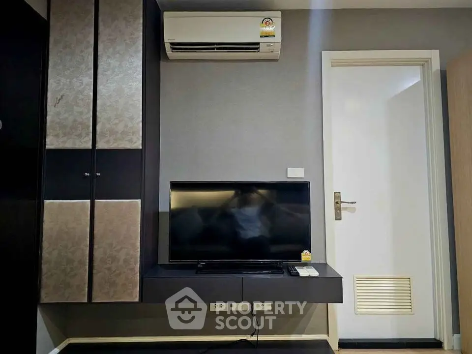 Modern living room with wall-mounted TV and air conditioning unit