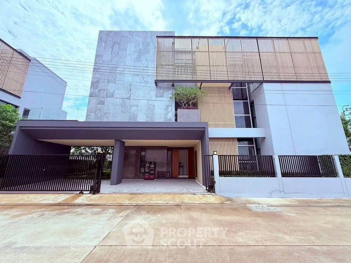 Modern architectural home with sleek facade and gated entrance, showcasing contemporary design and urban living.