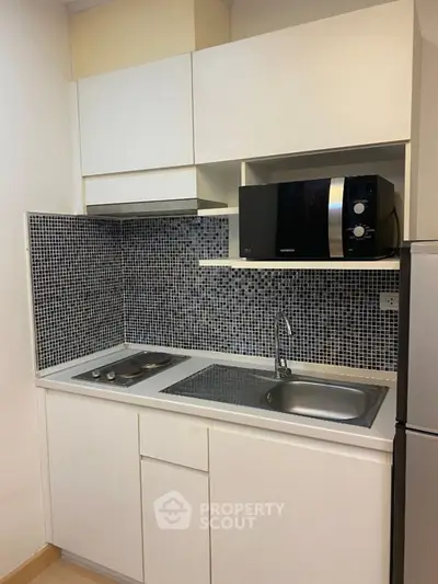 Modern compact kitchen with sleek appliances and stylish mosaic backsplash