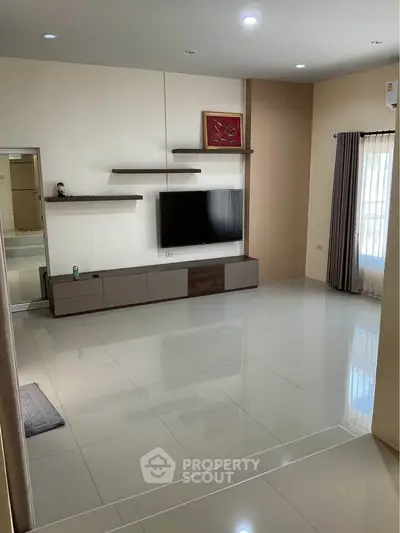 Spacious modern living room with sleek tile flooring and wall-mounted TV unit.