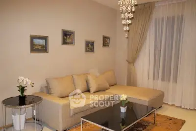 Elegant living room with modern beige sofa and chic chandelier lighting.