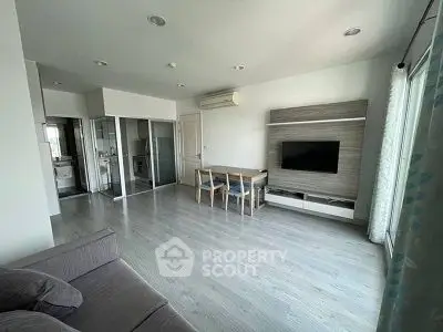 Modern living room with sleek design, featuring a wall-mounted TV and dining area, perfect for contemporary living.