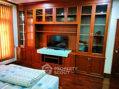 Spacious bedroom with elegant wooden built-in cabinets and cozy bedding