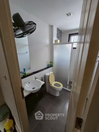 Modern bathroom with sleek fixtures and frosted glass shower in a cozy apartment.