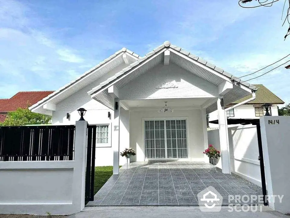 Charming white bungalow with spacious driveway and lush garden, perfect for family living.