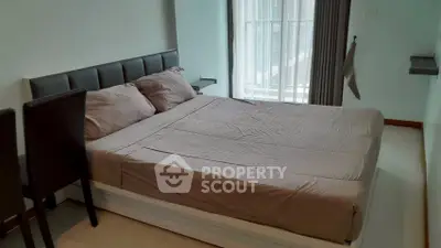 Modern bedroom with large bed and natural light from window, ideal for comfort and relaxation.