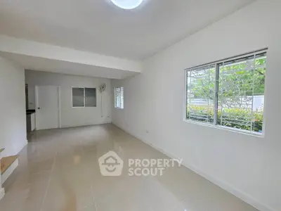 Spacious and bright living room with large windows and tiled flooring
