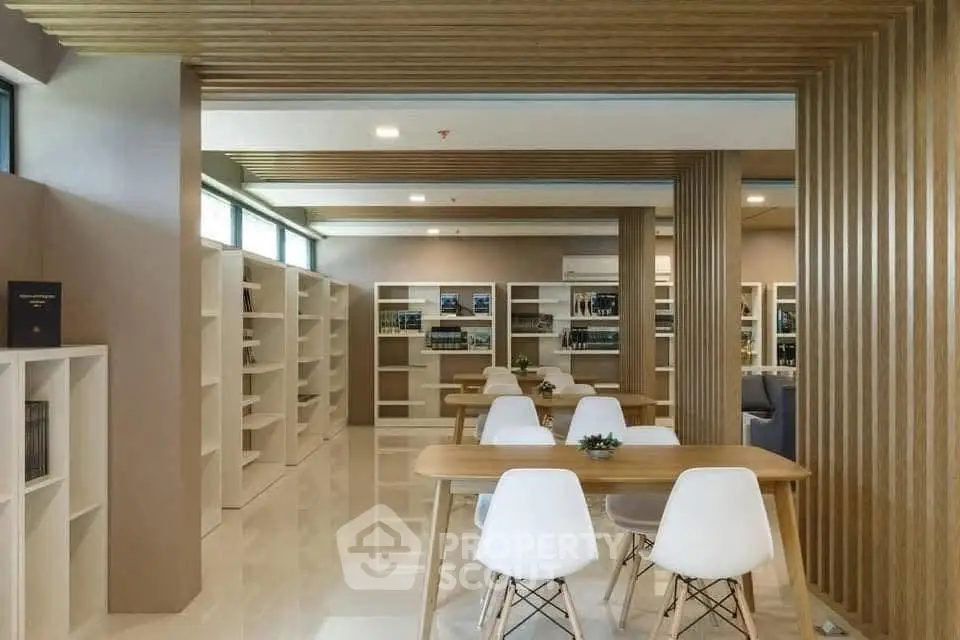 Modern library with sleek wooden decor and white chairs, perfect for study or relaxation.