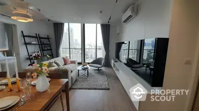 Spacious modern living room with large windows offering a panoramic city view, stylish furnishings, and an open-plan layout.