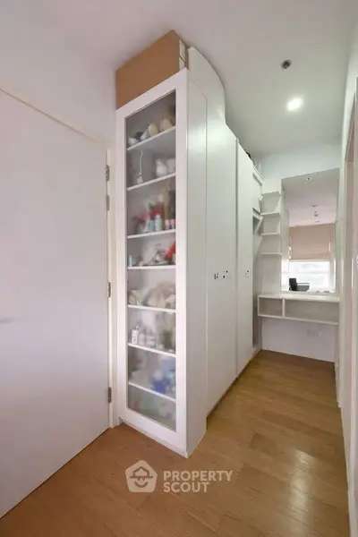 Modern storage area with sleek white cabinets and wooden flooring
