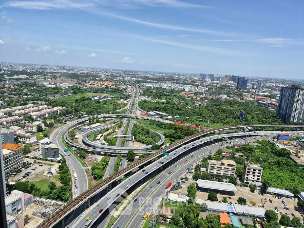 Stunning aerial view of urban landscape with highways and city skyline, perfect for real estate investment.