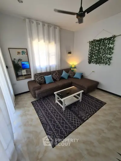 Cozy living room with sectional sofa, modern decor, and natural light.