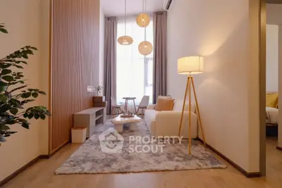 Modern living room with cozy decor and natural light, featuring stylish furniture and elegant lighting.