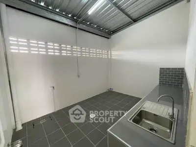 Modern minimalist kitchen with sleek tile flooring and stainless steel sink