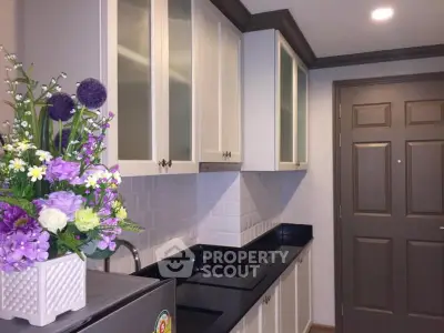 Charming kitchen with sleek black countertops and elegant cabinetry, perfect for modern living.