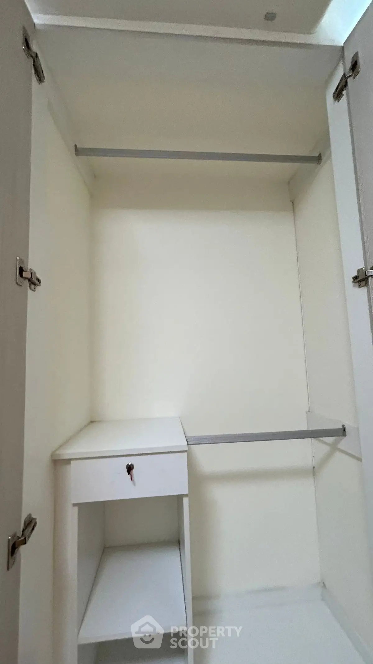 Spacious white walk-in closet with shelving and hanging rods.