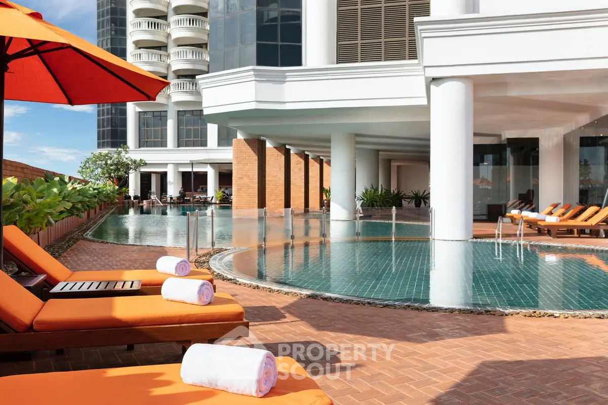 Luxurious poolside area with sun loungers and modern architecture, perfect for relaxation and leisure.