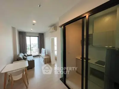 Modern apartment interior with open living room and kitchen, featuring large windows and stylish furniture.