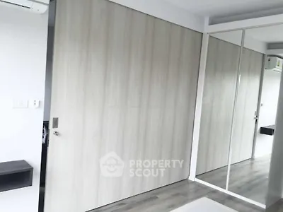 Modern bedroom with mirrored closet doors and sleek wooden flooring