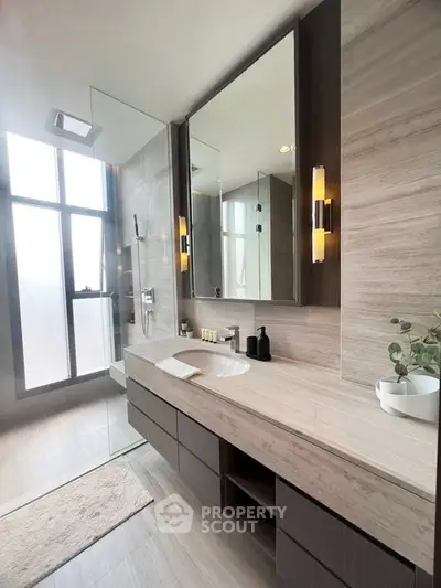 Luxurious modern bathroom with sleek design and elegant fixtures, featuring a spacious vanity and glass shower.