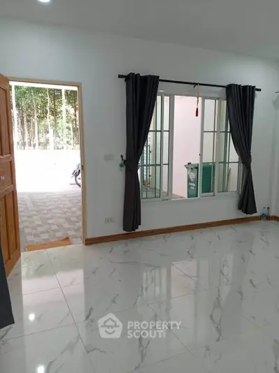 Spacious modern living room with marble flooring and large window view