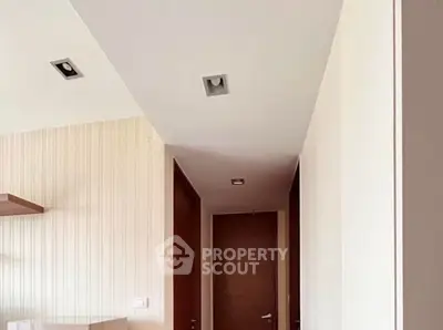 Modern hallway with wooden doors and recessed lighting