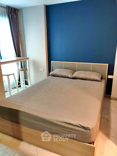 Modern bedroom with stylish blue accent wall and natural light