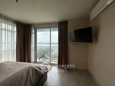 Spacious bedroom with balcony offering stunning river views and modern amenities.