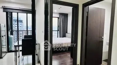 Modern apartment interior with bedroom and dining area, featuring large windows and city view.