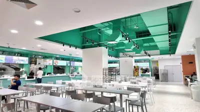 Modern food court with sleek design and ample seating in a commercial building.