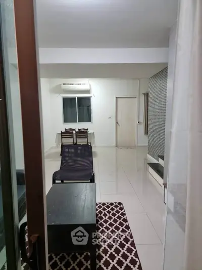 Spacious living room with modern furniture and tiled flooring, perfect for relaxation and entertainment.