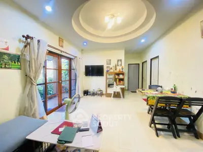 Spacious living room with modern ceiling design and garden view, perfect for family gatherings.