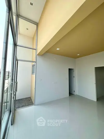 Spacious modern living room with high ceilings and large windows offering abundant natural light.