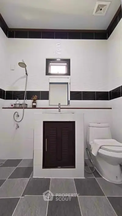 Modern bathroom with sleek design, featuring a shower and toilet in a stylish setting.
