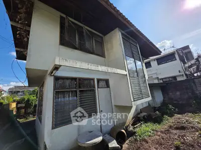 Charming two-story house with unique architectural design and spacious outdoor area.