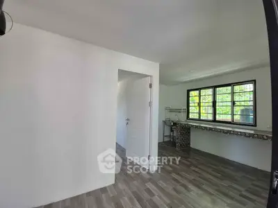 Spacious interior with modern flooring and large windows for natural light