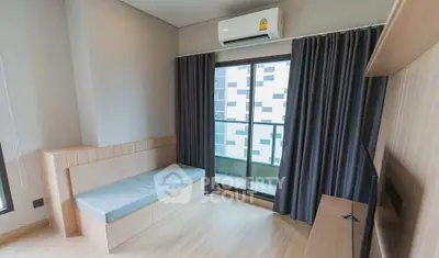 Modern living room with large window and air conditioning, featuring sleek wooden flooring and built-in seating.